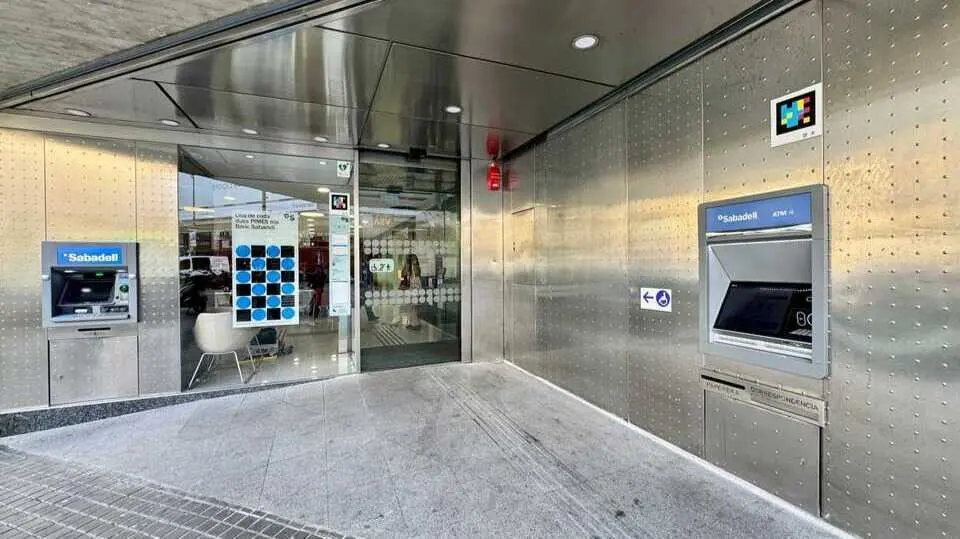 Imagen de la oficina 200 en la Rambla Catalunya, con los c&oacute;digos NaviLens en uno de sus cajeros autom&aacute;ticos. (Banco Sabadell)