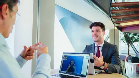 Un cliente de CaixaBank y un gestor hacen uso del servicio de videointerpretaci&oacute;n en lengua de signos SVisual en una oficina