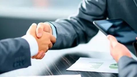 Apret&oacute;n de manos entre dos empresarios. (Archivo)